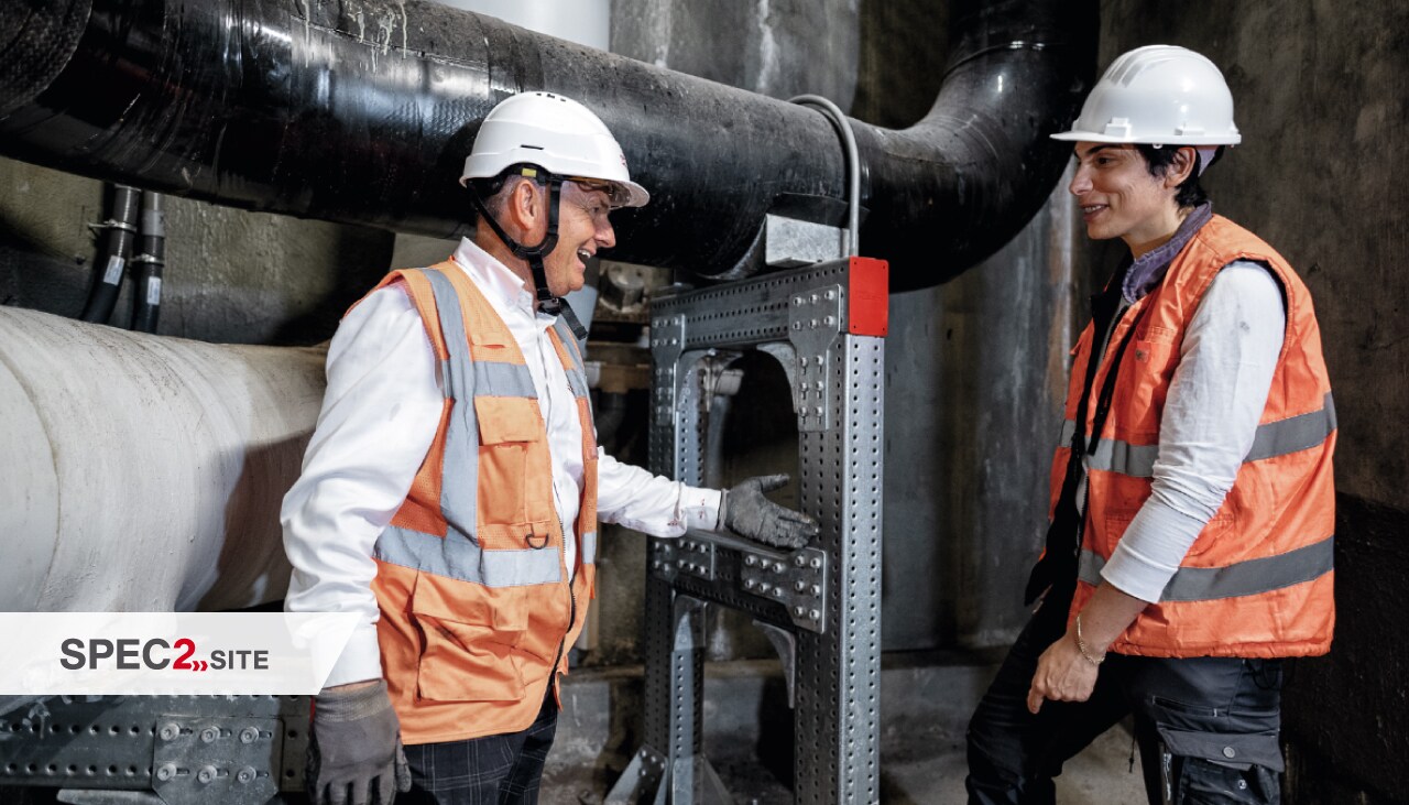 Ein Hilti Ingenieur und ein Kunde inspizieren ein modulares Schienensystem für Rohrleitungen
