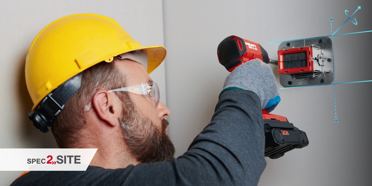 Un operaio utilizza un avvitatore cordless per installare un dispositivo antifuoco su una parete