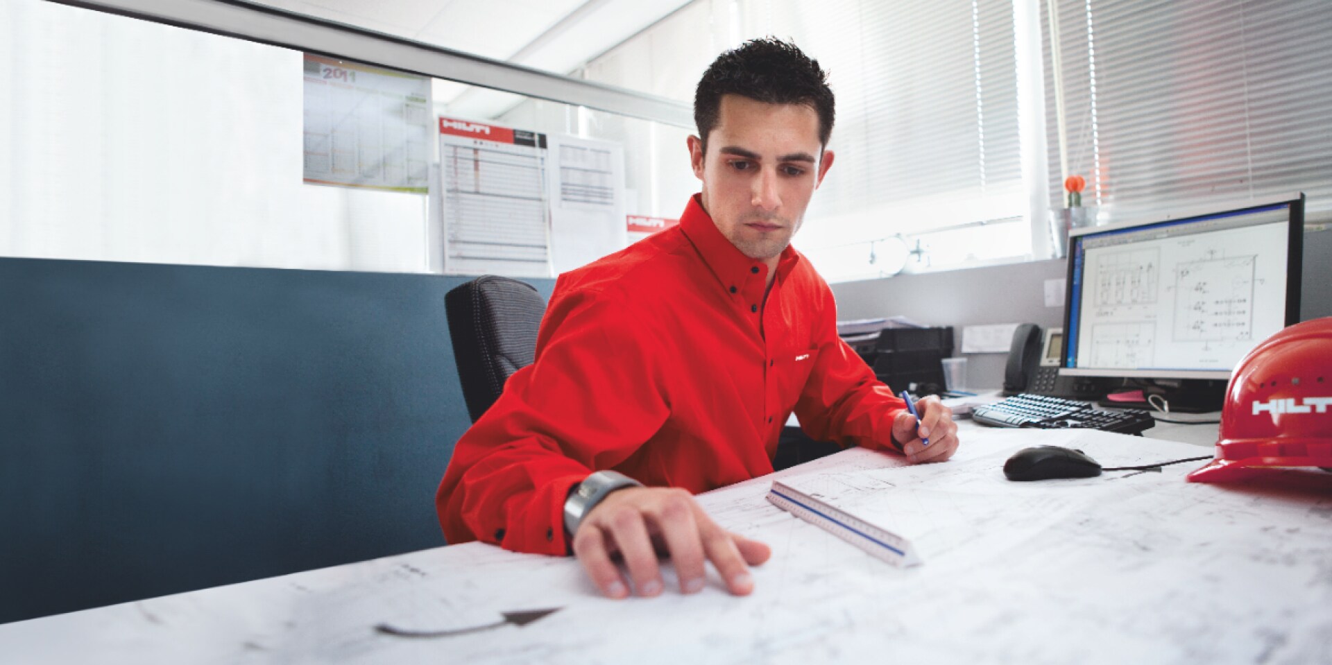 Fotografia di un ingegnere Hilti alla scrivania mentre stila un parere tecnico per un cliente.