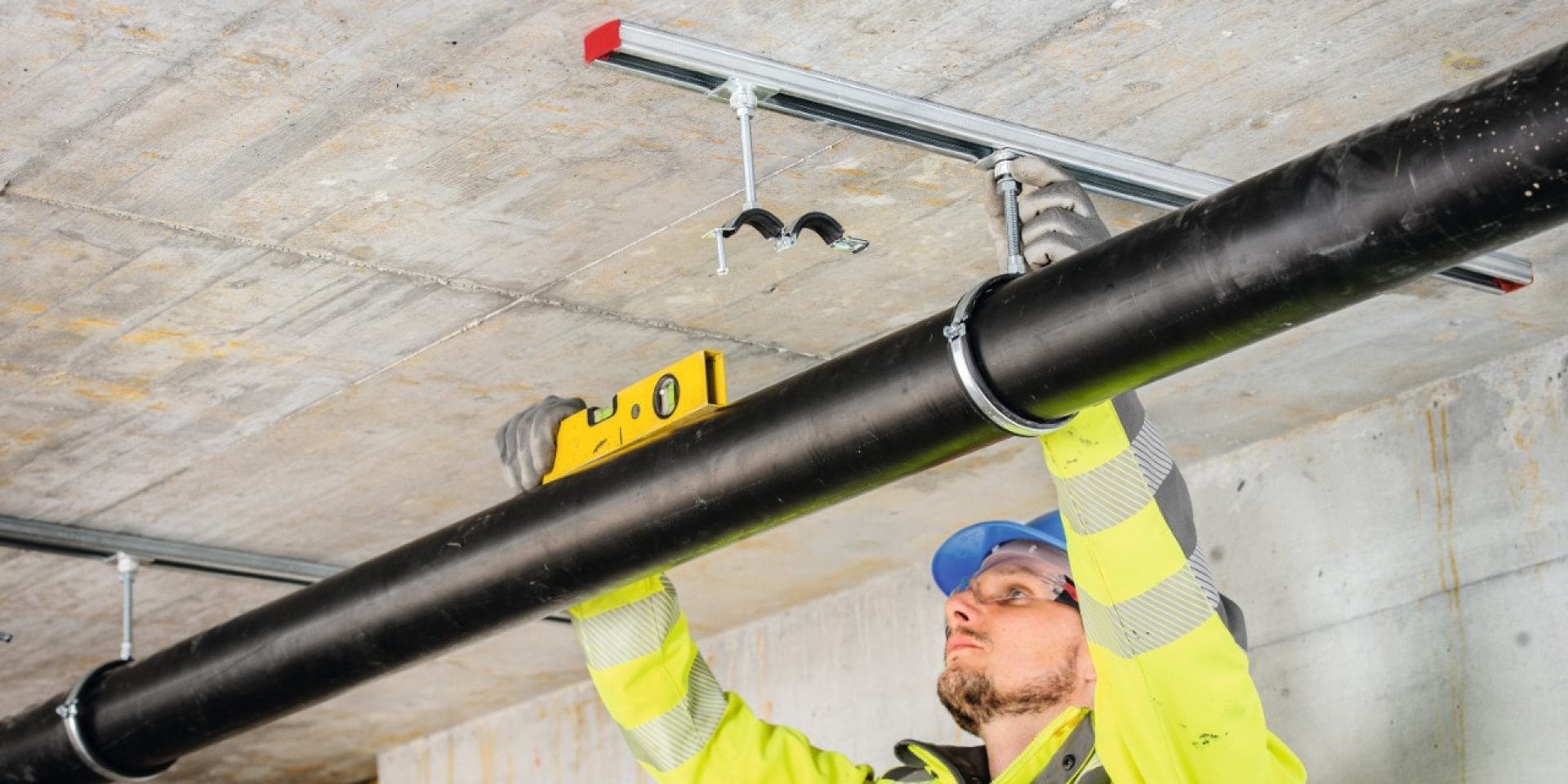 Componenti per installazione Hilti in uso per sospendere una tubazione su binari montati a soffitto